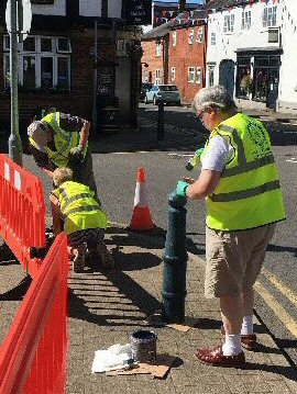 Photograph: Lutterworth Rotary Club members painting the bollards with fresh blue paint.
